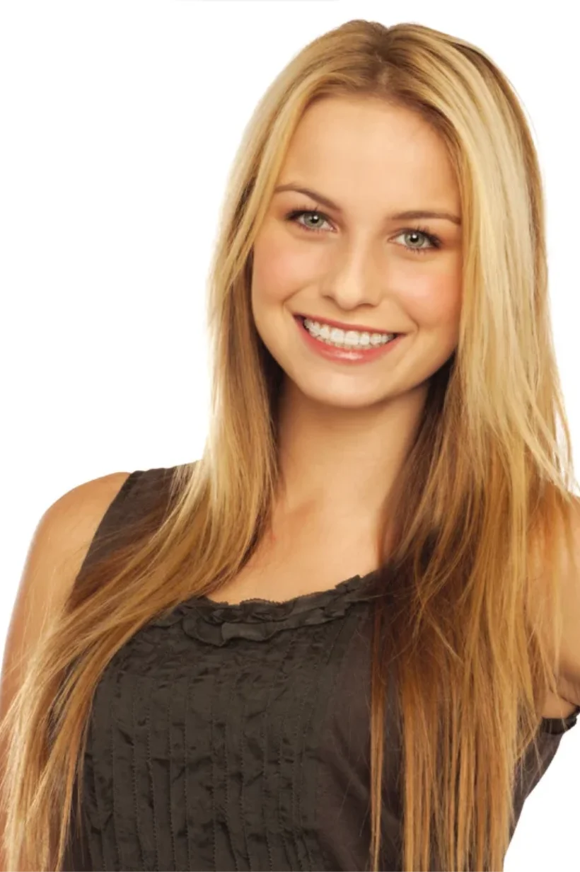 Fotografía de una mujer joven sonriendo con brackets estéticos