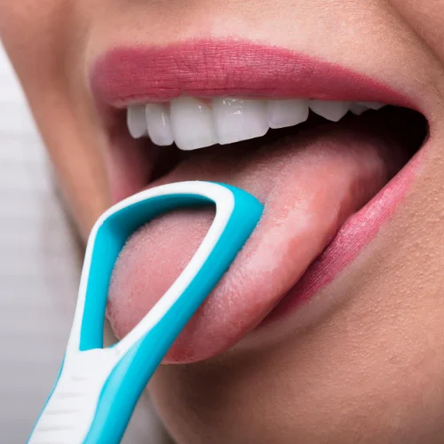 Fotografía de la lengua de una mujer sujeta por un instrumental de plástico