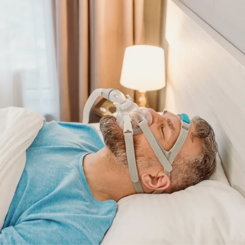 Fotografía de un hombre con una máscara de oxígeno tumbado en una cama
