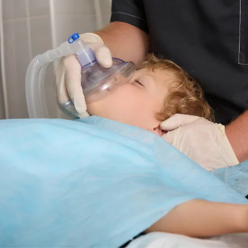 Fotografía de un niño con una máscara de oxígeno atendido por un sanitario
